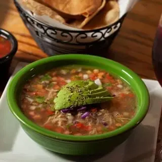 Caldo de Pollo served in a green bowl